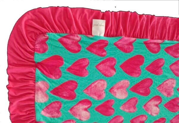 Reversible bamboo blanket showing ice cream floral print and pink hearts print with ruffle border