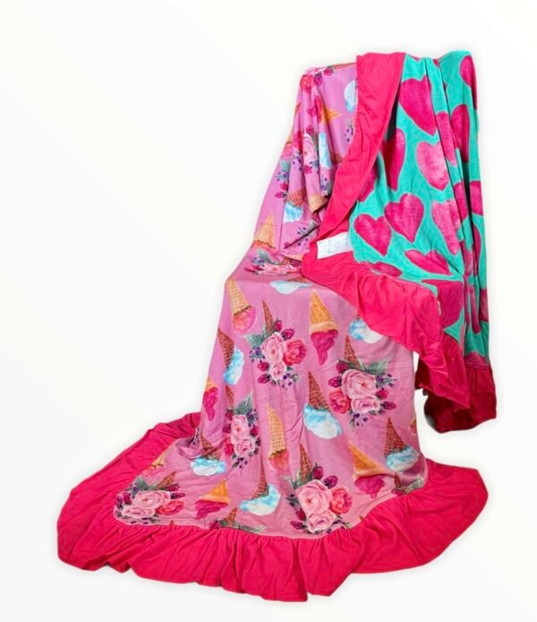 Reversible bamboo blanket showing ice cream floral print and pink hearts print with ruffle border