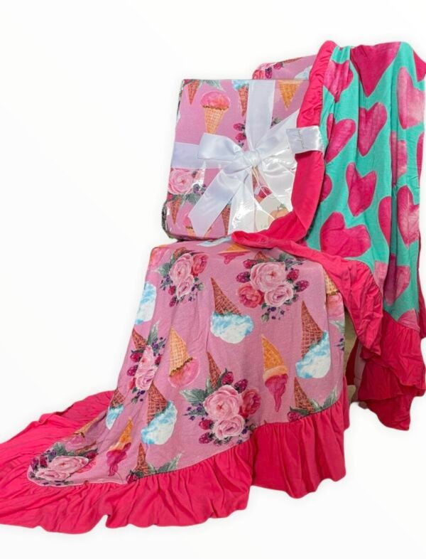 Reversible bamboo blanket showing ice cream floral print and pink hearts print with ruffle border